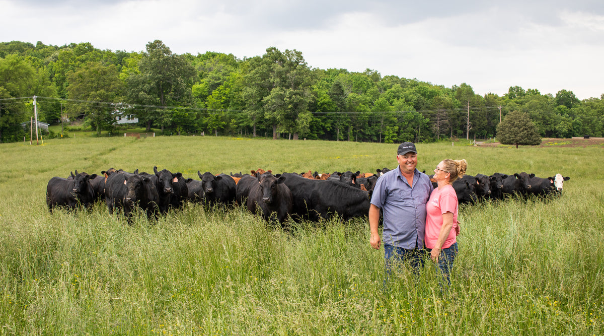 Farmer couple in pasture with cattle wearing Porter Road cap